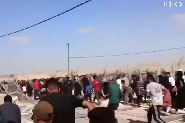 Gaza residents storm an aid distribution compound in Rafah after Hamas roadblocks collapse, May 27, 2024. (Screenshot: Kan 11 News)