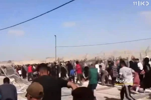 Gaza residents storm an aid distribution compound in Rafah after Hamas roadblocks collapse, May 27, 2024. (Screenshot: Kan 11 News)