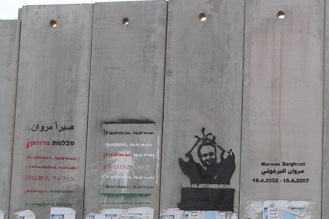 A mural of imprisoned Fatah leader Marwan Barghouti painted on the Israeli security barrier near the Qalandia checkpoint, north of Jerusalem. (Photo: Wikimedia Commons)