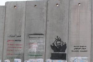 A mural of imprisoned Fatah leader Marwan Barghouti painted on the Israeli security barrier near the Qalandia checkpoint, north of Jerusalem. (Photo: Wikimedia Commons)