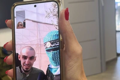 Rom Braslavski and a Hamas terrorist of the 'Arrow' unit in a phone call with the Braslavski family ahead of Rom's release, October 13, 2025 Photo: (Photo used under section 27A of the copyright law).
