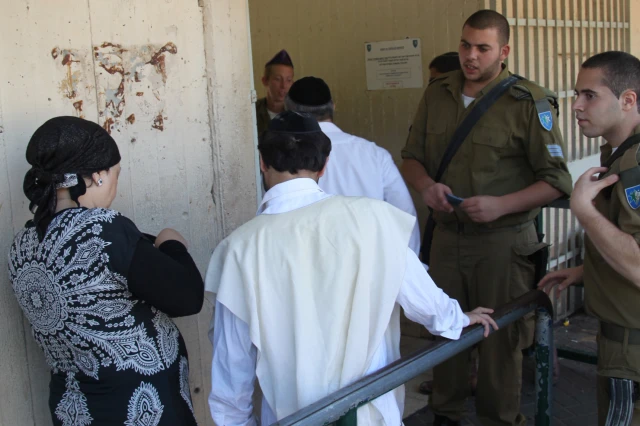 Ultra-orthodox Jewish men arrive at the Bakum Reception and Sorting base in Tel Hashomer in Israel, on August 1, 2013. The largest numbers so far of ultra-orthodox new recruits to the Israeli army arrived at the Bakum army base on August 1. Most of them are expected to be absorbed in the Netzah Yehuda Battalion, under the Nahal Haredi. Photo by Flash90