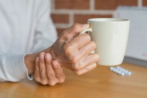 Illustration: Close-up of an elderly woman steadying her hand while drinking, illustrating symptoms associated with Parkinson’s disease.
Photo: Shutterstock
