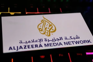 Illustrative image: Smartphone screen displaying the Al Jazeera Media Network logo, placed on a computer keyboard. Photo: Shutterstock.