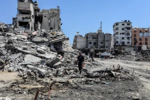 Palestinians walk next to destroyed buildings and pools with stagnant water in Khan Yunis, in the southern Gaza Strip, on July 19, 2024. Photo: Shutterstock