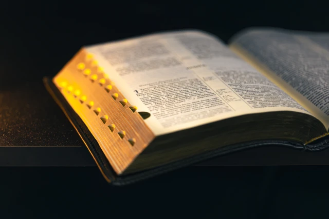 Open Bible on a black background.(Shutterstock)