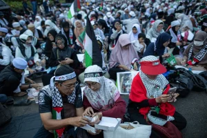 Protesters are having their Iftar meals to break their fast during a mass Iftar dinner organized for displaced Palestinians in Jakarta, Indonesia, on April 7, 2024 (Photo: Afriadi Hikmal/NurPhoto/Via REUTERS).