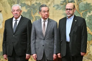 Mahmoud al-Aloul, Vice Chairman of the Central Committee of Palestinian organisation and political party Fatah, China's Foreign Minister Wang Yi, and Mussa Abu Marzuk, senior member of the Palestinian terrorist group Hamas, attend an event at the Diaoyutai State Guesthouse in Beijing on July 23, 2024 (PEDRO PARDO/Pool via REUTERS).