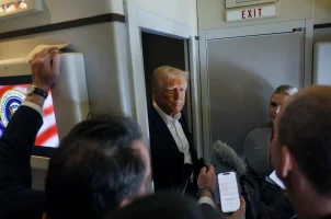 Reporters ask questions to U.S. President Donald Trump aboard Air Force One during a flight from Las Vegas, Nevada, to Miami, Florida, U.S., January 25, 2025. REUTERS/Leah Millis