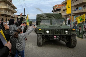 Lebanese supporters of pro-Iranian Hezbollah throw rice at a Lebanese army jeep as it drives by in the southern Lebanese town of Bint Jbeil. January 26, 2025, Photo by Marwan Naamani/dpa via Reuters Connect