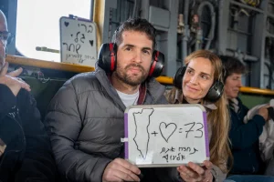 Released hostage, Sagui Dekel-Chen, who was seized during the deadly October 7, 2023 attack by Hamas, sits next to his wife as he flies to central Israel, on February 15, 2025. Words in Hebrew read, "Bring them back to us", which refer to the 73 hostages still in Gaza. Photo: GPO