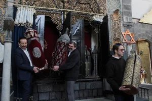 Henry Hamra and members of a Syrian Jewish delegation who are visiting Syria for the first time in decades hold a Torah Case in a Jewish synagogue in Damascus, Syria February 18, 2025. REUTERS/Firas Makdesi