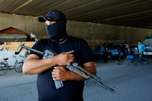 A gunman stands as Syrian security forces check vehicles entering Druze town of Jaramana, following deadly clashes between Sunnis and Druze in southeast of Damascus, Syria April 29, 2025. REUTERS/Yamam Al Shaar