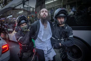 Ultra-Orthodox men scuffle with police and "Brothers in Arms" protesters in the ultra-orthodox Jewish neighborhood of Meah Shearim in Jerusalem at a protest calling for equal conscription laws. March 31, 2024 (Photo: Chaim Goldberg/Flash90).