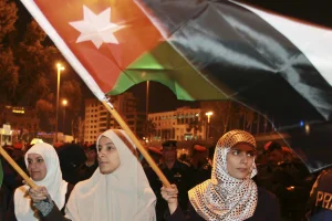 Anti-government protesters hold Jordanian flags as they demonstrate (REUTERS/Muhammad Hamed)