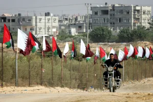 Member of Hamas security forces rides a motorcycle next to Palestinian and Qatar flags during preparations for the celebratory reception of Qatar's Emir Sheik Hamad bin Khalifa al-Thani, in Khan Younis in the southern Gaza Strip on October 22, 2012. The emir of pro-Western Qatar will become the first head of state to enter the blockaded Gaza Strip on Tuesday, in a high-profile visit breaking the isolation of the Iranian-backed Islamist movement Hamas that seized power in 2007. Photo by Abed Rahim Khatib / Flash 90