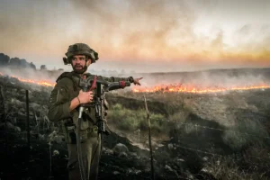 Israeli Security forces try to extinguish a fire near the scene of where a rocket fired from Lebanon hit a car and critically injured two people near Nafah Junction, in the Golan Heights, July 9, 2024 (Photo: Michael Giladi/Flash90).