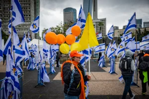 People seen at Hostage Square in Tel Aviv, on the day of the release of the bodies of four Israeli hostages from Hamas captivity, February 20, 2025. The color orange has become a powerful symbol of the plight of the red-headed Bibas children. Photo by Chaim Goldberg/Flash90