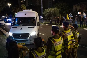 People and Israeli security forces pay their respects as the convoy carrying the bodies of hostages arrive at the Abu Kabir Forensic Institute in Tel Aviv, on October 16, 2025. Photo by Yonatan Sindel/Flash90