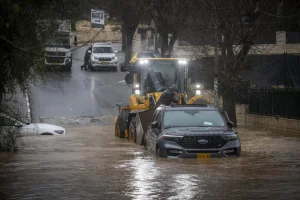 Heavy flooding inundates a road in the village of Abu Gosh, outside Jerusalem, as vehicles and heavy machinery make their way through floodwaters following winter rains. Photo by Oren Ben Hakoon/Flash90