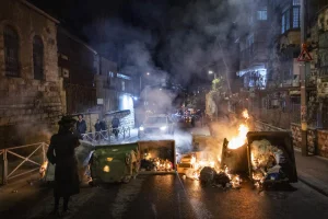 Ultra-Orthodox Jewish men block a road and clash with police during a protest against the autopsy of toddlers who died earlier in a daycare, in Jerusalem, January 19, 2026. Photo by Chaim Goldberg/Flash90