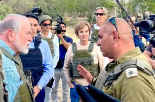US Amb Huckabee Mike Huckabee discuss the atrocities in Kfar Aza with IDF Major Liad Diamond. (photo credit: All Israel News staff)