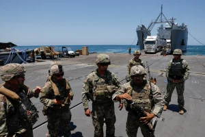 Soldiers stand at Trident Pier, a temporary pier to deliver aid, off the Gaza Strip, amid the ongoing conflict between Israel and Hamas, near the Gaza coast, June 25, 2024. REUTERS/Amir Cohen