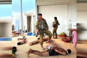 IDF soldiers guard Hamas gunmen found in a greenhouse at Moshav Yated, close to the southern Gaza border, October 7, 2023. (Screenshot taken from Channel 12/Keshet TV, used in accordance with Clause 27a of the Copyright Law)