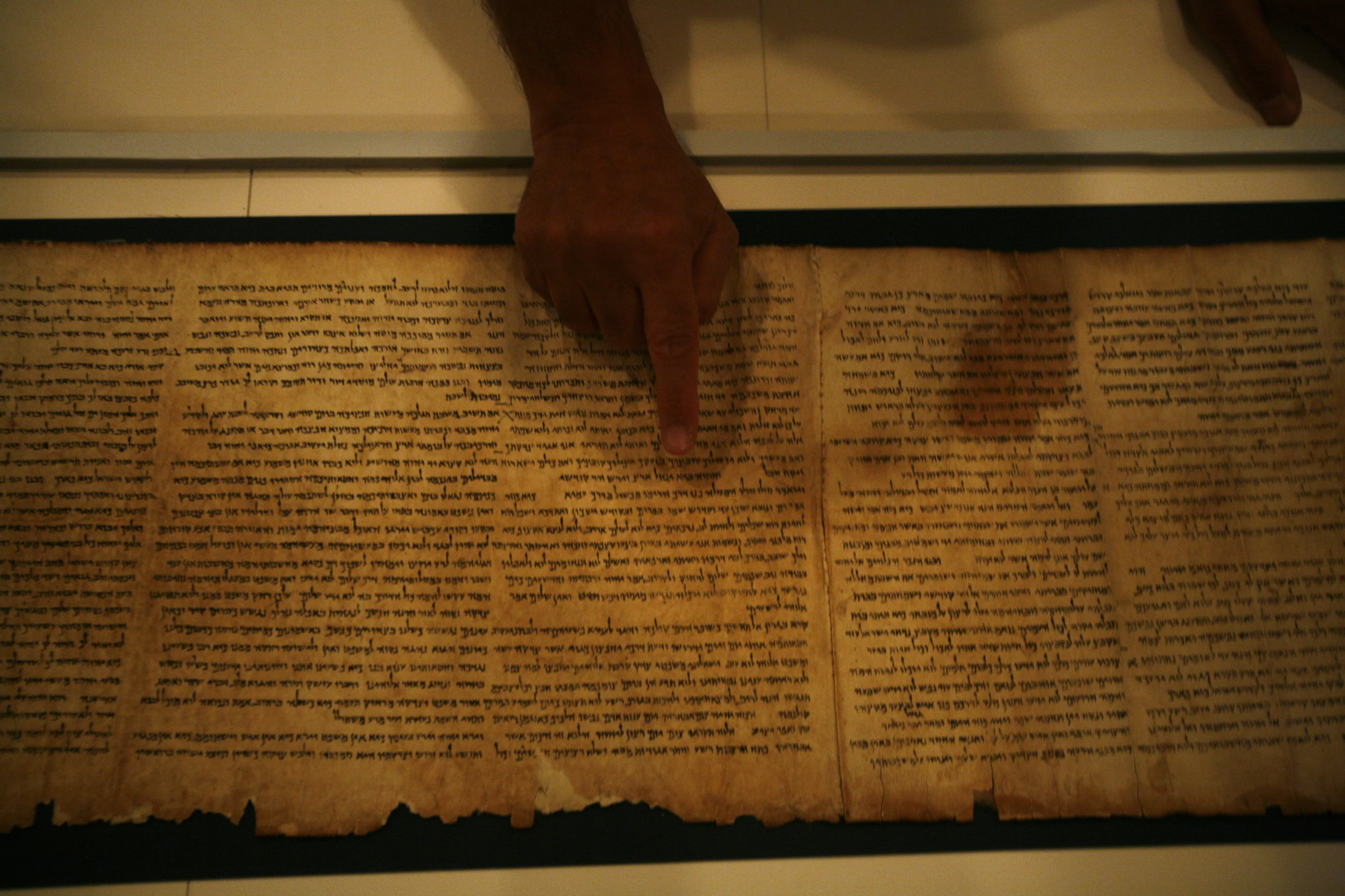 Adolfo Roitman, curator of the Dead sea Scrolls, points at the original Isaiah Scroll, one of the Dead Sea Scrolls