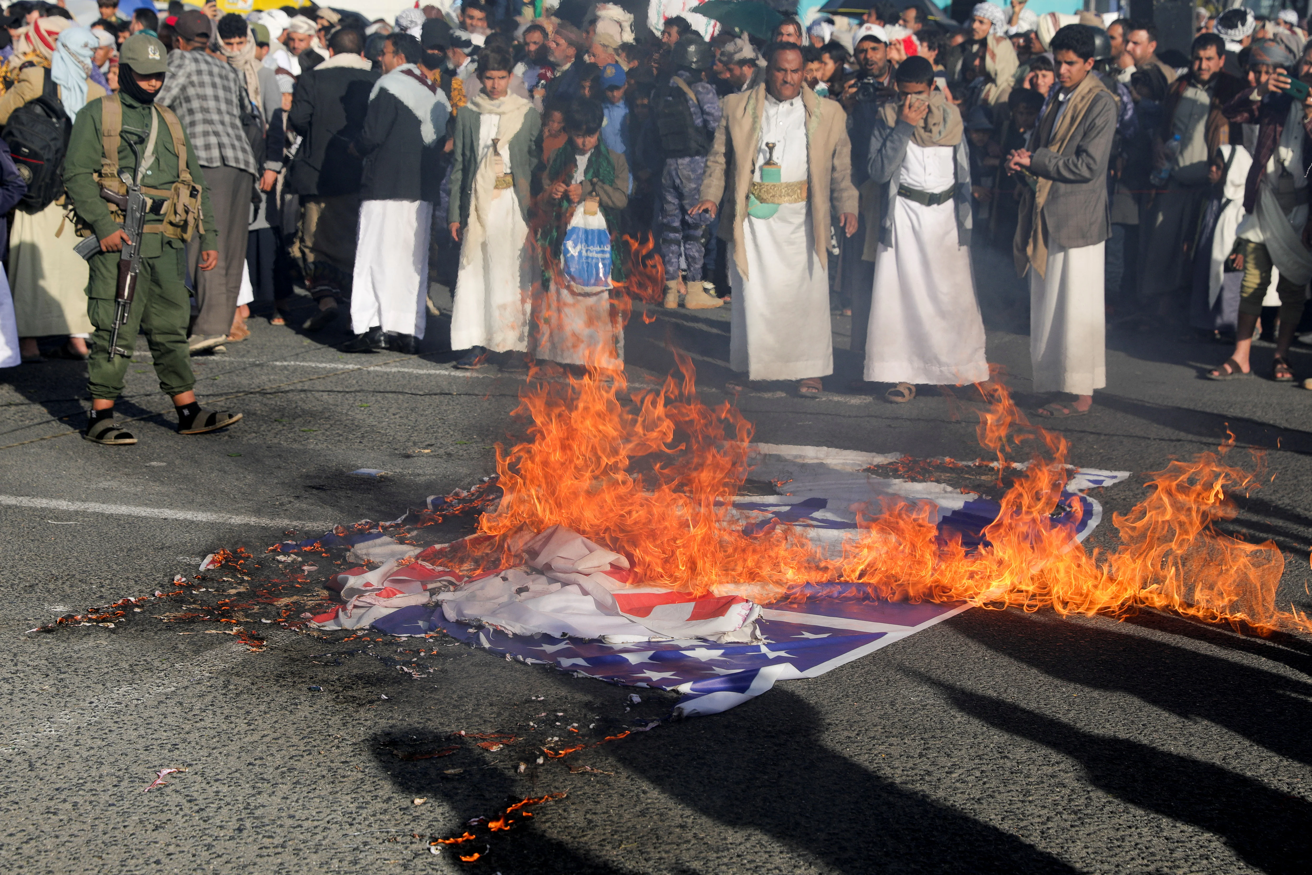 A banner depicting U.S. and Israeli flags is burned in Sanaa, Yemen December 20, 2024. REUTERS/Khaled Abdullah