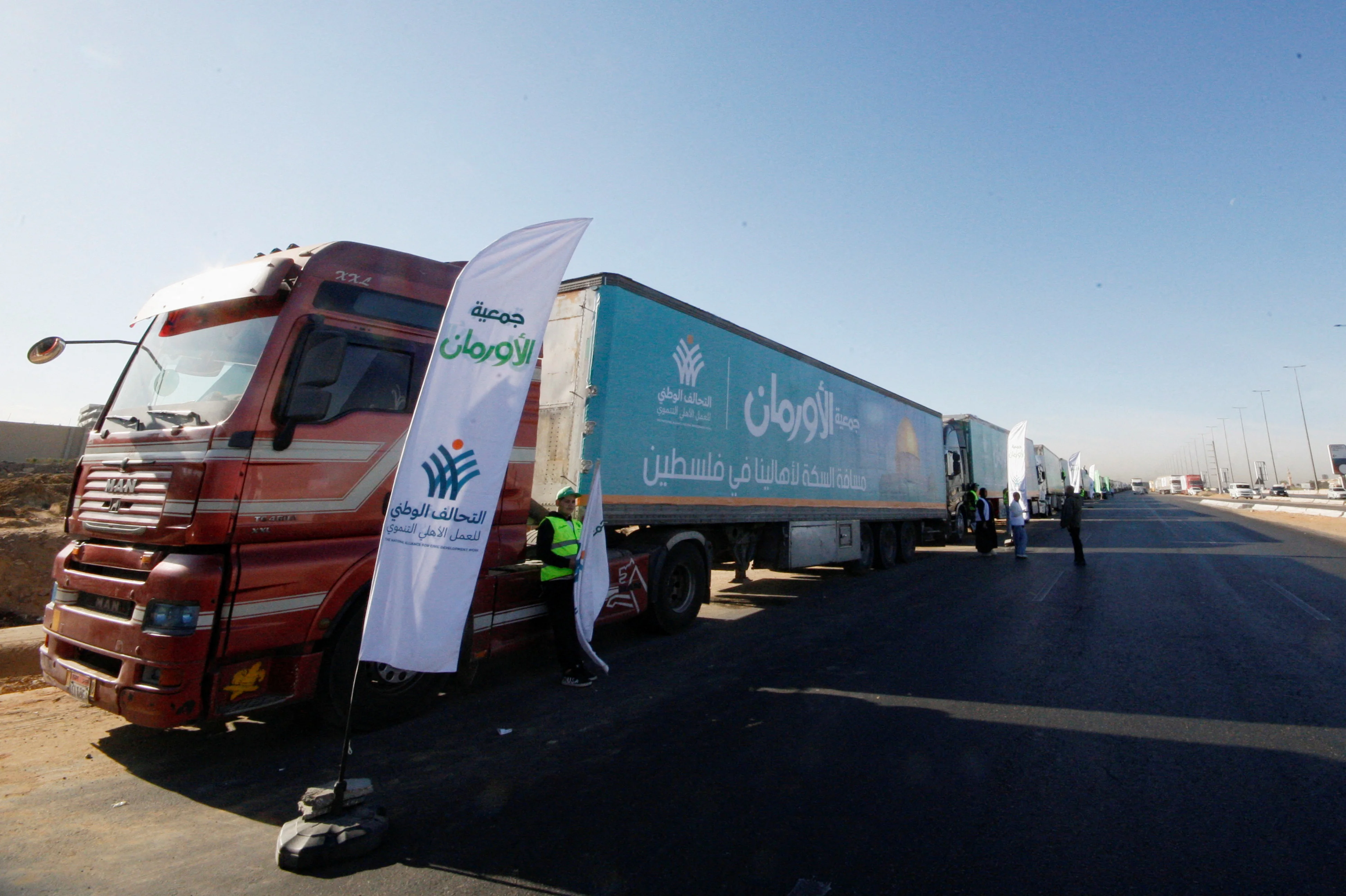 Trucks carrying humanitarian aid from Egypt's National Alliance For Civil Development Work (NACSW) to Gaza wait on the desert road (Cairo—Ismailia) heading to the Rafah border crossing to enter Gaza, amid a ceasefire between Israel and Hamas, in Cairo, Egypt, January 21, 2025. REUTERS/Shokry Hussein