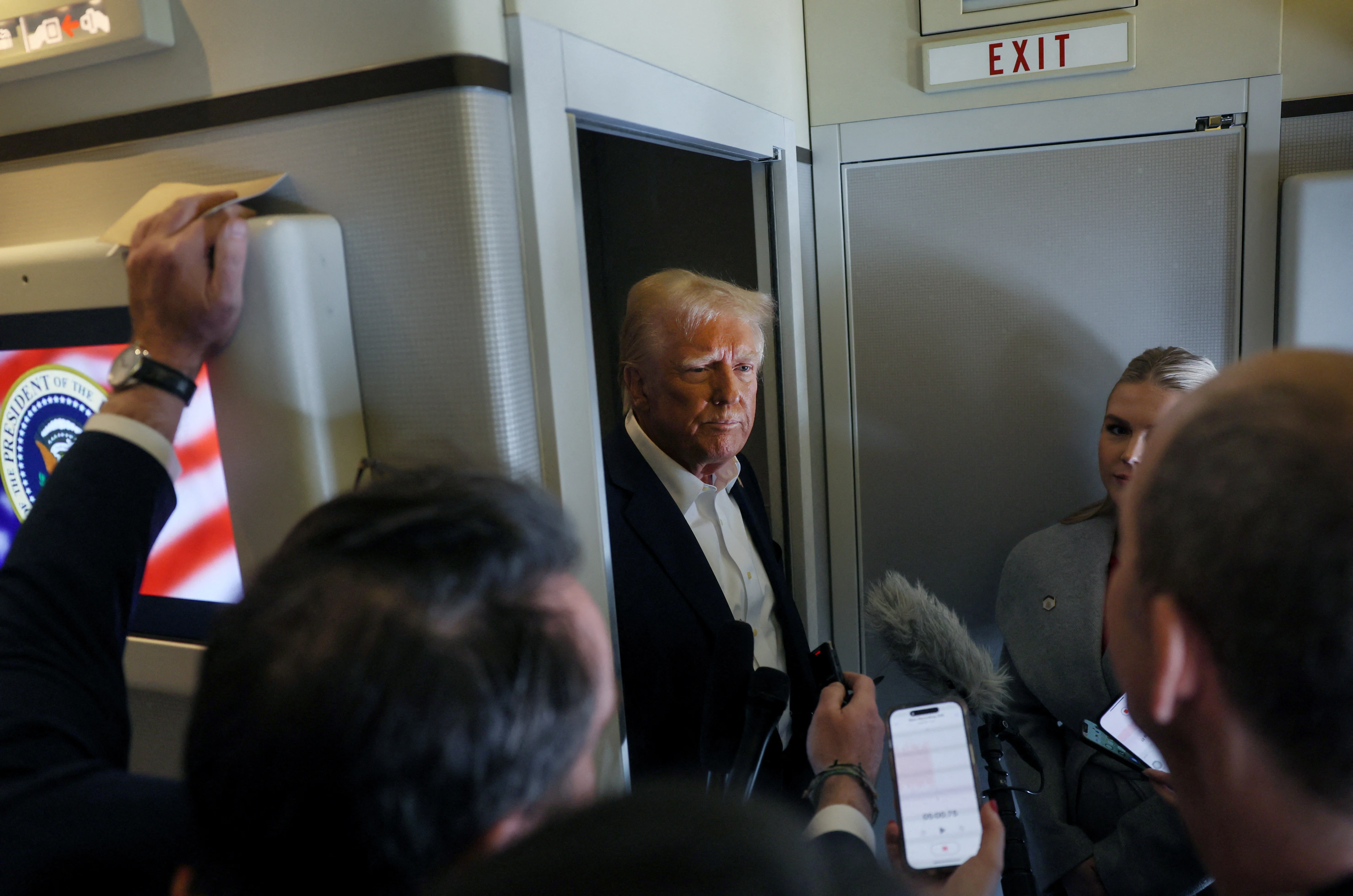 Reporters ask questions to U.S. President Donald Trump aboard Air Force One during a flight from Las Vegas, Nevada, to Miami, Florida, U.S., January 25, 2025. REUTERS/Leah Millis