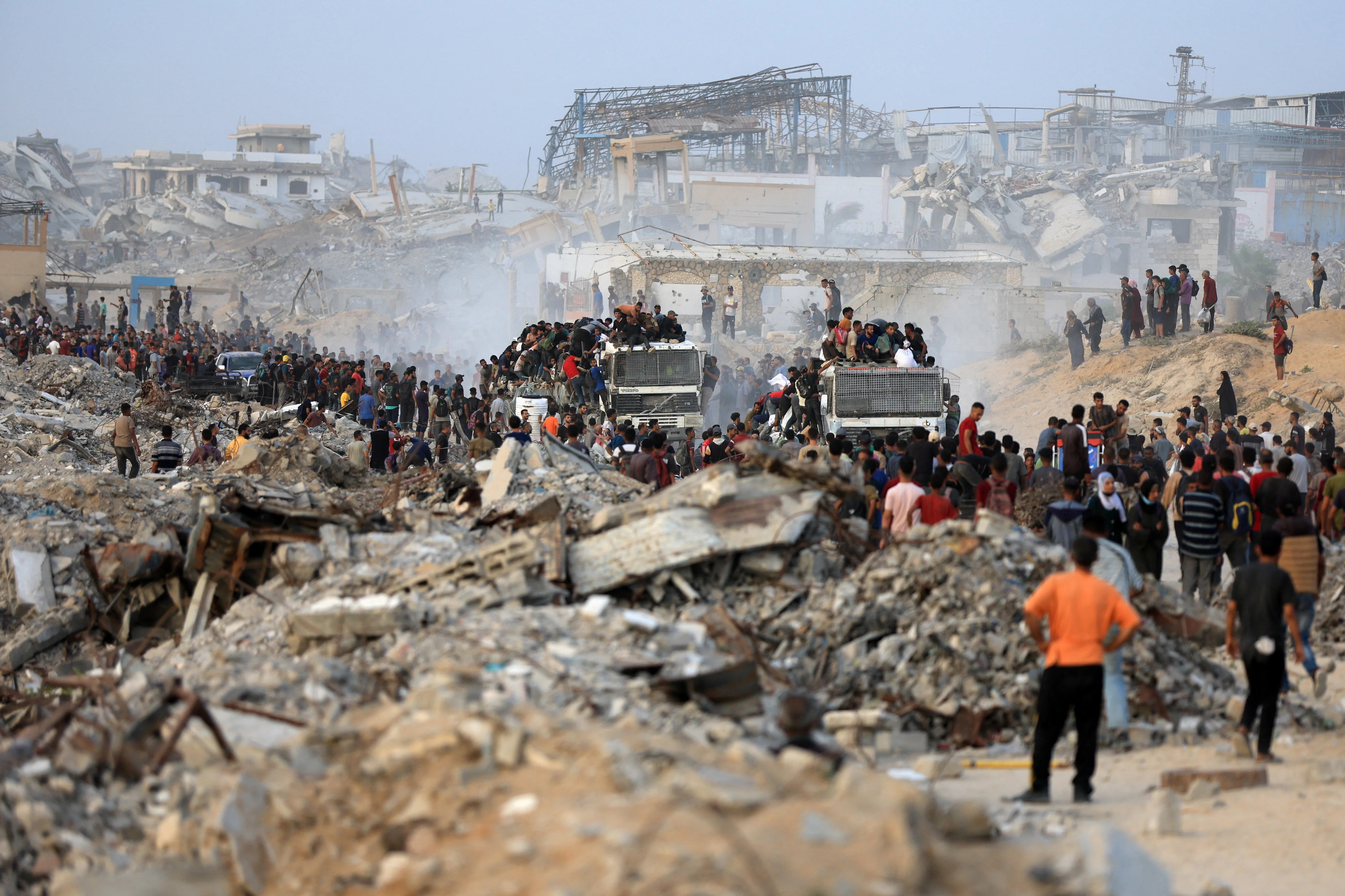 Palestinians climb onto trucks carrying aid supplies that entered Gaza through Israel, in Beit Lahia, in the northern Gaza Strip July 29, 2025. REUTERS/Dawoud Abu Alkas