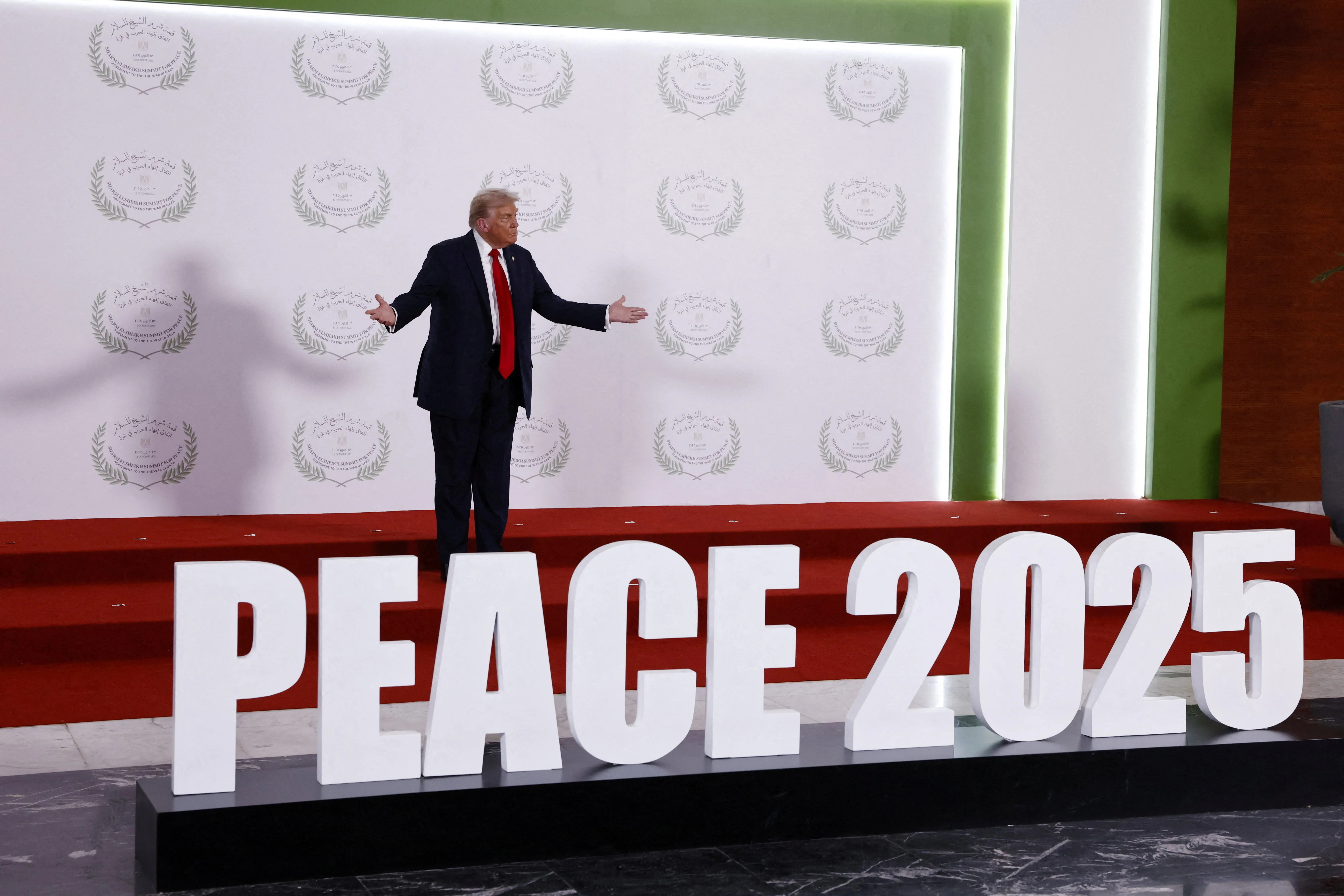 U.S. President Donald Trump waits to greet world leaders before a family photo at a world leaders' summit on ending the Gaza war, amid a U.S.-brokered prisoner-hostage swap and ceasefire deal between Israel and Hamas, in Sharm el-Sheikh, Egypt, October 13, 2025. Photo: Yoan Valat/Pool via Reuters Connect