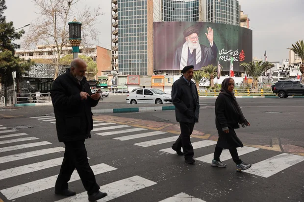 People walk near a billboard of Iran's late Supreme Leader Ayatollah Ali Khamenei on a street, after he was killed in Israeli and U.S. strikes, in Tehran, Iran, March 2, 2026. (Photo: Majid Asgaripour/WANA via Reuters)