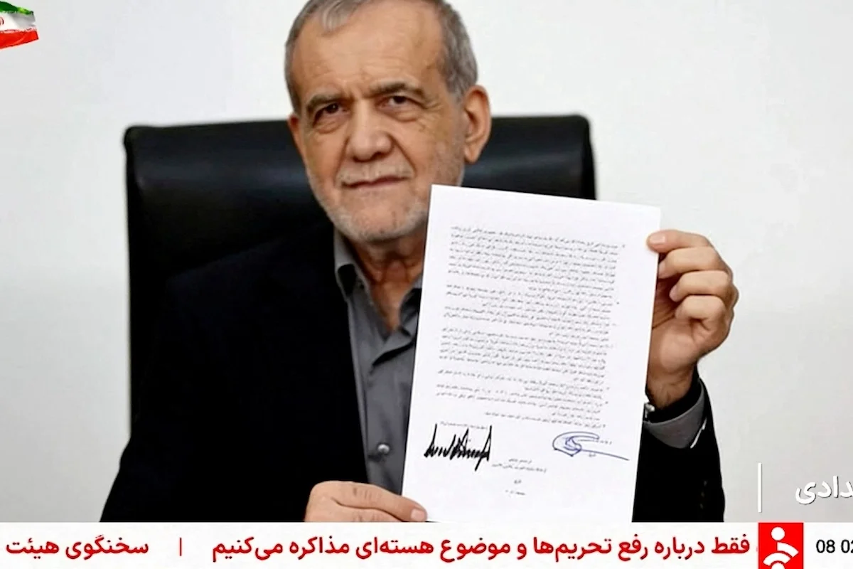 Iran’s President Masoud Pezeshkian holds a memorandum signed with U.S. President Donald Trump