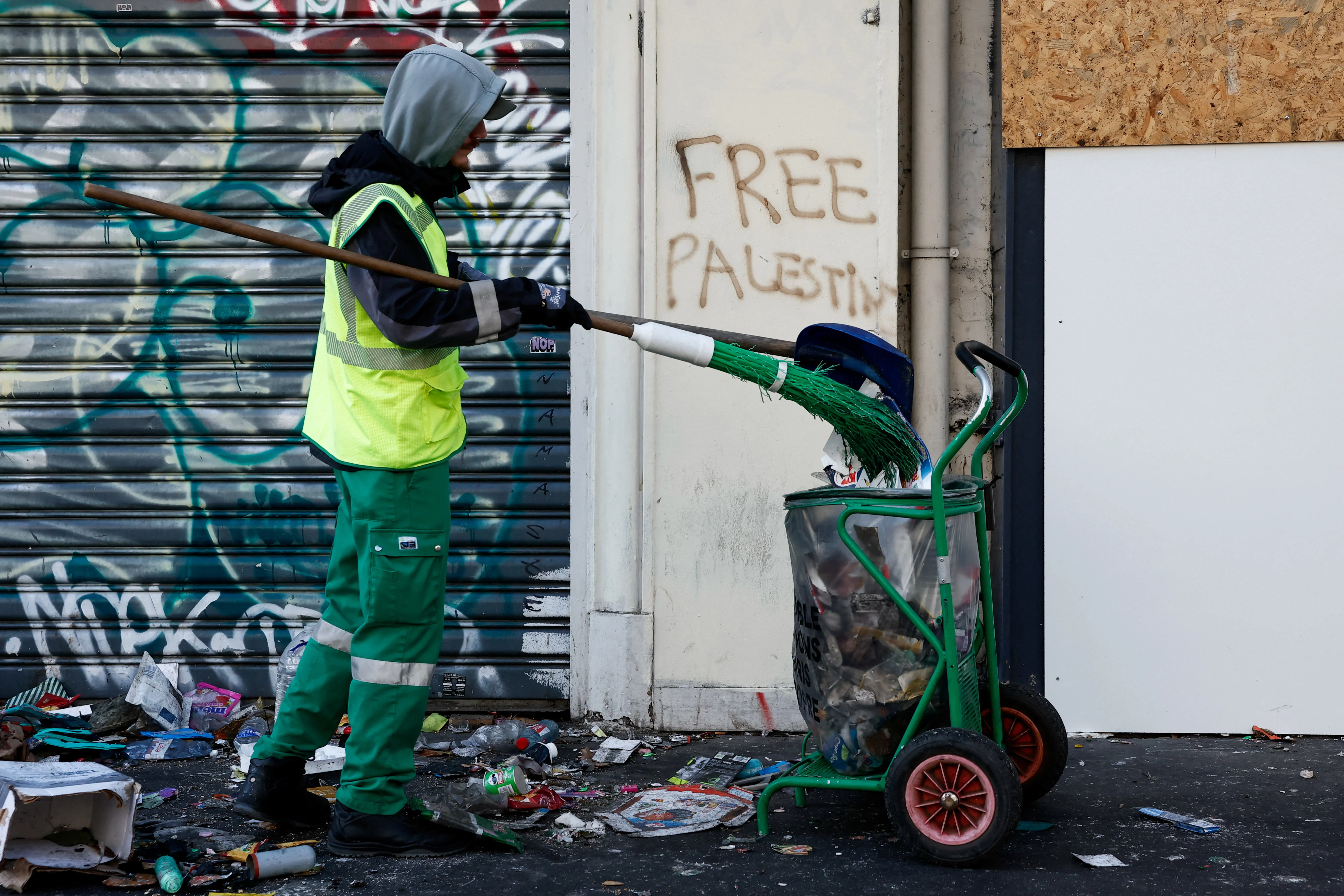 A worker cleans a street the day after clashes during a national day of demonstrations against the cost of living and rising fuel prices, in Paris, France, October 18, 2026. Reuters Connect by Benoit Tessier