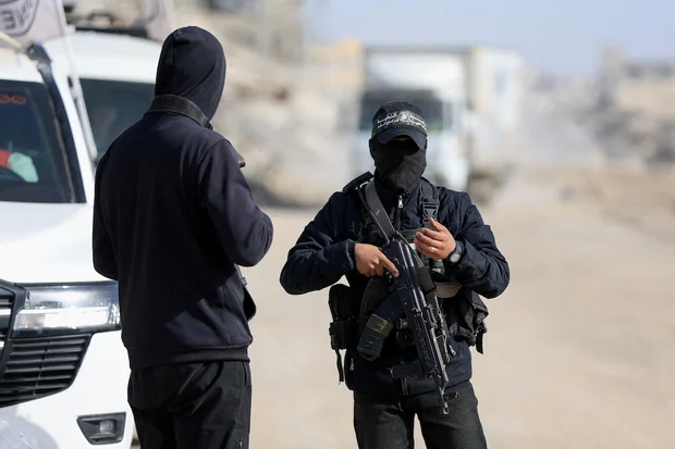 Palestinian Hamas militants stand at a site as Hamas says it continues to search for the body of the last deceased hostage, in Gaza City December 8, 2025.REUTERS/Dawoud Abu Alkas