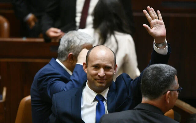 Newly elected Prime Minister Naftali Bennett waves after their new coalition wins Knesset approval, June 13, 2021 (Photo: Haim Zach/GPO)