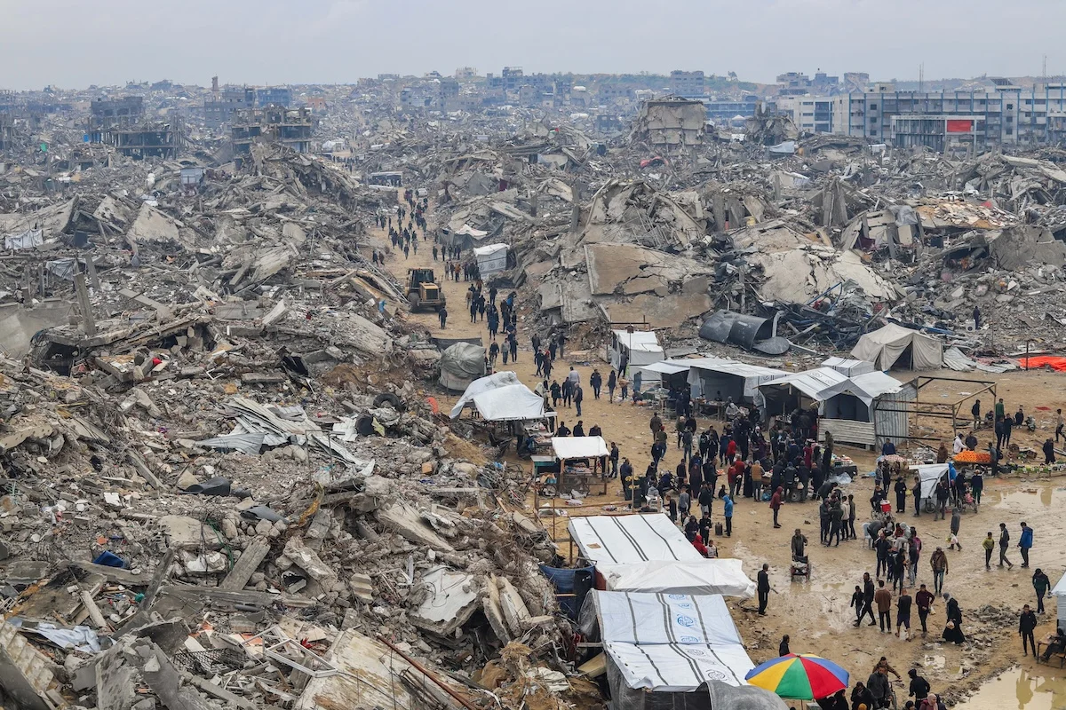 Palestinians shop at the market around the destruction caused in recent war