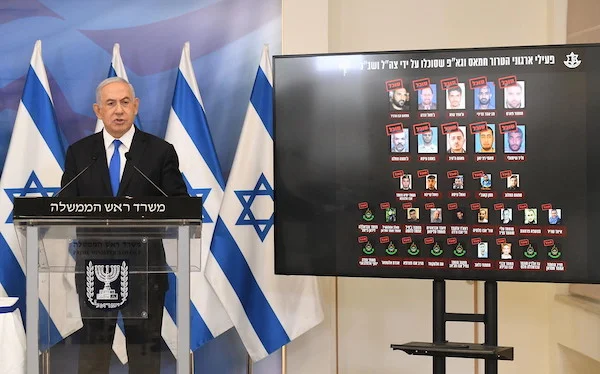 Prime Minister Benjamin Netanyahu gives a statement at a press conference after the Gaza ceasefire, Tel Aviv, May 21, 2021. At his side is a screen showing Gaza terror commanders killed in Operation Guardian of the Walls (Amos Ben Gershom/GPO)