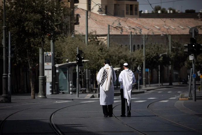 Jewish men walk with a prayer shawls in Jerusalem, on Yom Kippur, the Day of Atonement, September 28, 2020