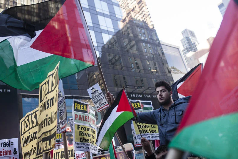 pro-Palestine demonstrators chants chant slogans and hold up signs as they march next to a Pro-Israel protest in Times Square, New york on October 18, 2015. Photo by Amir Levy/Flash90