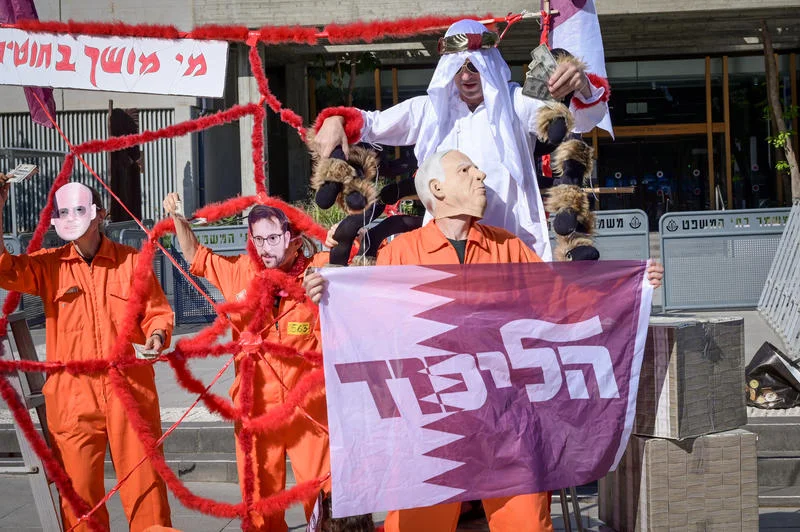 Protesters accusing Prime Minister Netanyahu of being paid by Qatar via his aides Feldstein and Urich, seen on the right. The protester impersonating Netanyahu holds a flag showing the Likud Party logo on a Qatari Flag. April 21, 2025. Photo by Avshalom Sassoni/Flash90