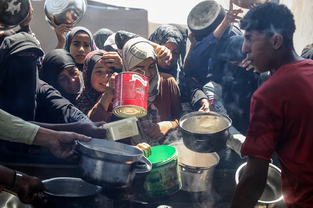Palestinians receive meals from volunteers in the Mawasi area of ​​Khan Yunis, in the southern Gaza Strip, on April 26, 2025. Photo by Abed Rahim Khatib/Flash90