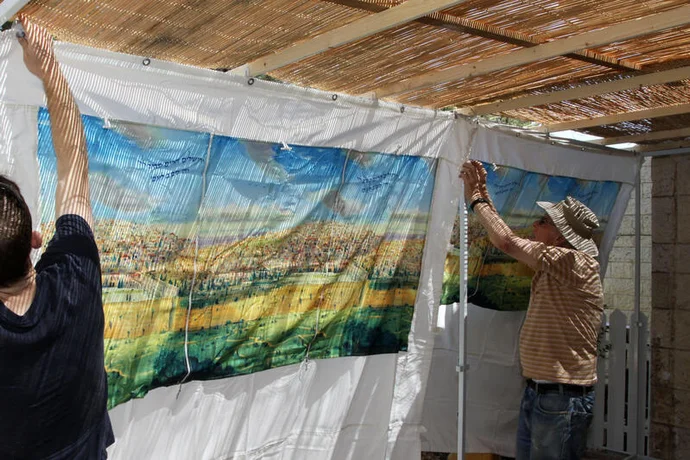 A grandfather and his grandson seen building and decorating a sukkah