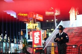 A police officer guards in Times Square at night, Manhattan, New York City, USA, October 28, 2016. Mendy Hechtman