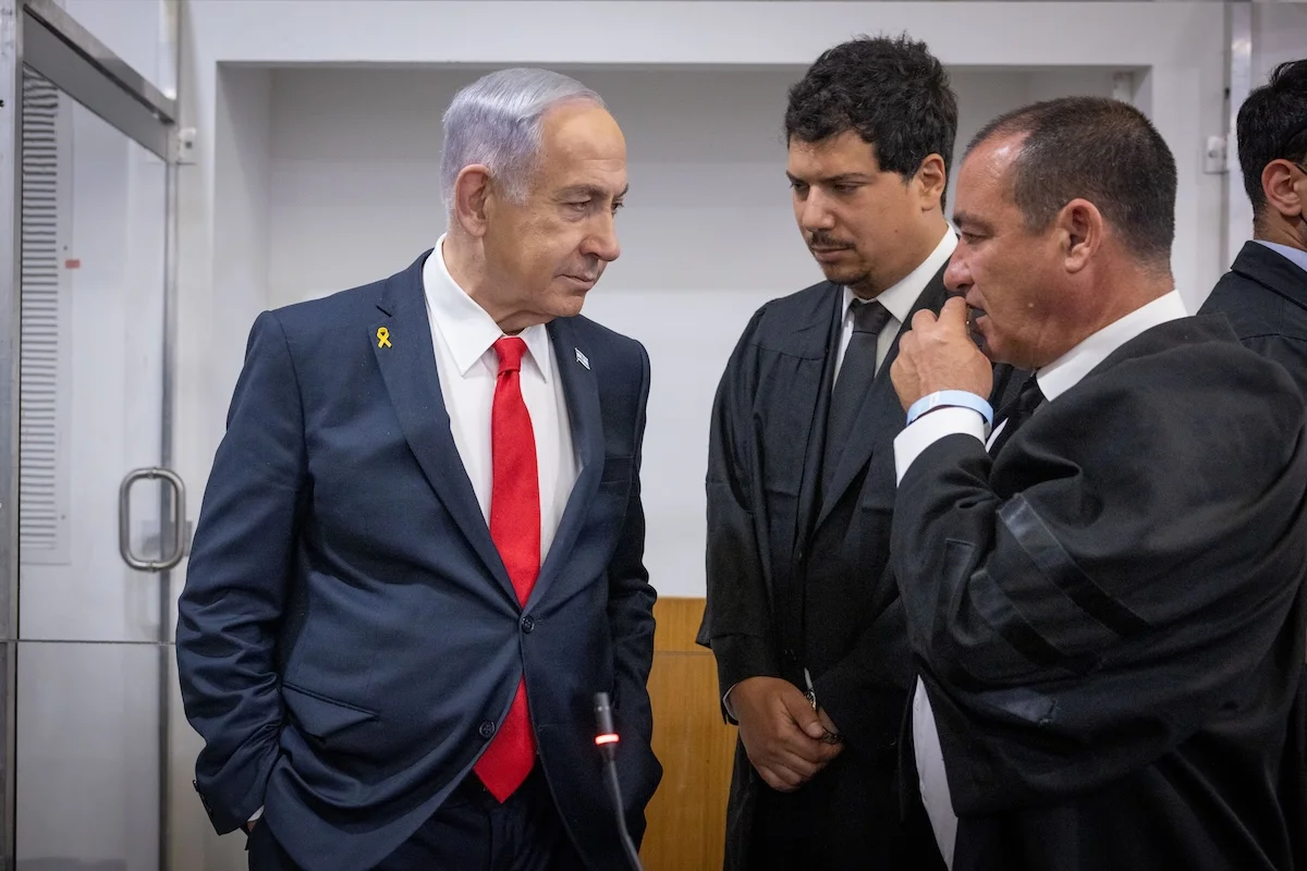 Israeli Prime Minister Benjamin Netanyahu speaks with his lawyer Amit Hadad
