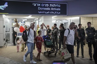 Passengers from Flydubai flight FZ1073 walk with their family members through the arrivals hall at Ben Gurion International Airport near Tel Aviv, after their original flight from Dubai to Israel was diverted to Saudi Arabia following a suspected terror attack, September 30, 2026. Photo by Flash90