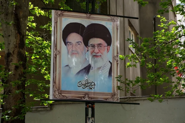 Two former Ayatollah pictures printed and hung on a rack. Islamic Republic of Iran establisher Ruhollah Khomeini on the left and Ali Khamenei on the right. (Photo: Shutterstock)